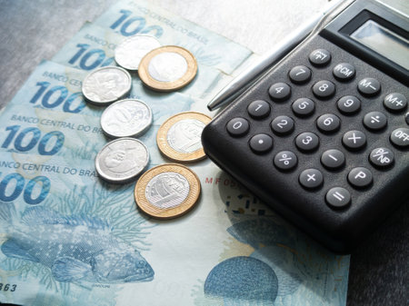 Finance concept one hundred reais bills and coins with calculator and pen brazilian money.の写真素材