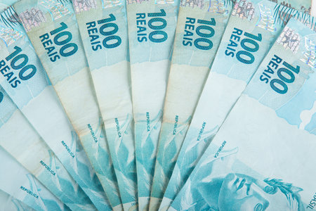Brazilian money. A close-up image showcasing a fan of crisp 100 Brazilian Reais banknotes.の写真素材
