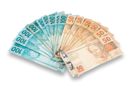 Brazilian currency spread out in fan shape with 100 and 50 Reais banknotes on white background.の写真素材