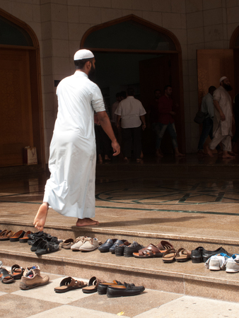 Dubai, UAE - March, 03, 2017: A man entering the mosque to the prayer call, leaving the shoes in the entrance.のeditorial素材