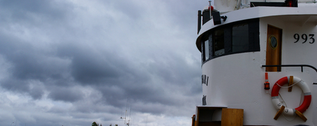 Image of the bridge of a fishing boat docked in a harbor in Iceland in a cloudy day.の写真素材