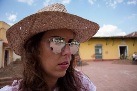 Close-up portrait of a young brunette woman with mirror sunglassesの写真素材