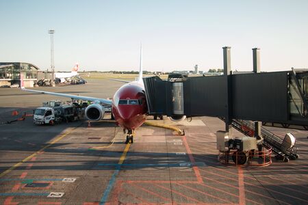 Copenhagen airport, Denmark - August 24, 2019: Boeing 737-800 of Norwegian airlines, being boarded by passenger access bridge at Copenhague-Kastrup airportのeditorial素材