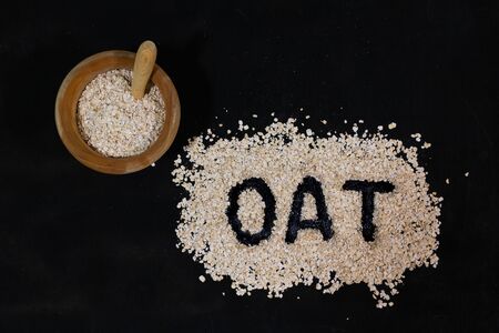 Concept of healthy eating: oat bran in a wooden bowl and the wordの写真素材