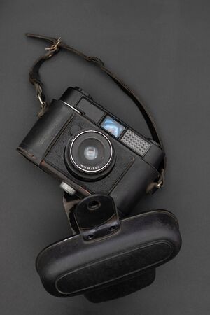 Closeup of an old 60s camera with its leather case on gray background. Photography conceptの写真素材