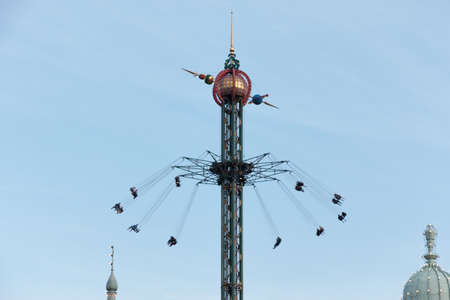 Copenhagen, Denmark - August 22, 2019: Amusement park carousel at the top with people enjoying the attraction in Copenhagen's Tivoli parkのeditorial素材