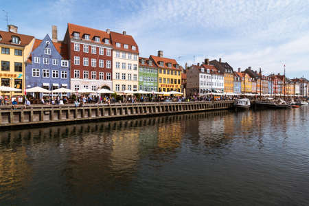 Copenhagen, Denmark - August 22, 2019: Famous Nyhavn pier with colorful buildings with people enjoying the terraces in Copenhagen, Denmarkのeditorial素材