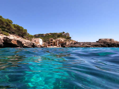 Cala s'Almunia, Majorca, Spain - August 7, 2020: View from the water of the fishermen's houses located in Cala s'Almunia in Majorca. A natural cove with transparent watersのeditorial素材