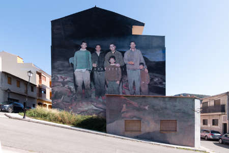 Fanzara (CastellÃ³n), Spain - September 20, 2020: Graffiti of a group of hunters on their prey with the "coexistence" poster created by the artist Axel Void, in the small town of CastellÃ³n (Spain) as part of MIAU (Unfinished Museum of Urban Art) in Fanzaのeditorial素材