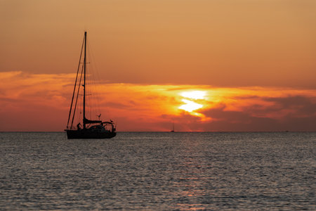 Seascape of silhouette of a sailing ship in the ocean at sunset. Vacation conceptの写真素材