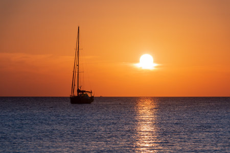 Silhouette of a sailing ship in the ocean at sunset over blue waters. Sea conceptの写真素材
