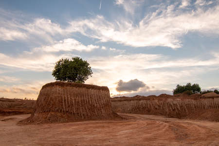An isolated tree in the middle of a large excavation on a small island. Environment conceptの写真素材