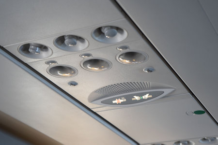 Overhead lights, air conditioning and safety signs in the plane cabin. Travel concept