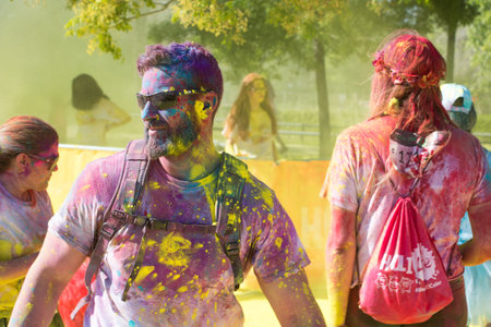 Valencia, Spain - April 27, 2019: Young man portrait during the Holi life race, covered with multi...