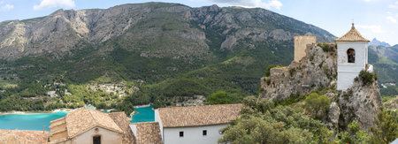 Panoramic view of the old bell tower of Guadalest with the Serrella mountain range in the background and the Guadalest reservoir in the lower part in the province of Alicante, Spain. nature tourism conceptの写真素材