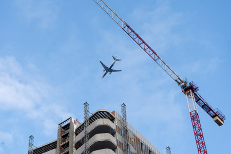Valencia, Spain - December 19, 2021: A plane from the Transavia company flies over buildings under construction in the cityのeditorial素材