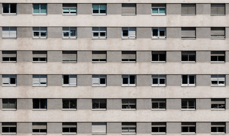 Building facade in gray tones with a geometric pattern of windows with shutters. Architecture conceptの写真素材