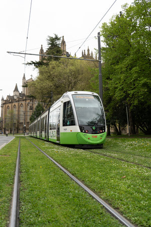 Vitoria, Spain - April 14, 2022: Electric tram circulating on tracks covered with grass through the city of Vitoria, Pais Vasco, Spainのeditorial素材