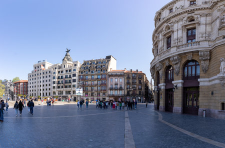 Bilbao, Spain - April 15, 2022: Plaza del Arriaga in Bilbao with groups of tourists waiting for a tour with the facade of the Arriaga or Antzokia Theater on the side. Basque Country in northern Spain. Cultural tourism conceptのeditorial素材
