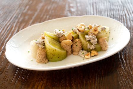 Studio shot of a bowl of leek salad with a meuniere sauce, gourmet style. Spanish cuisine conceptの写真素材