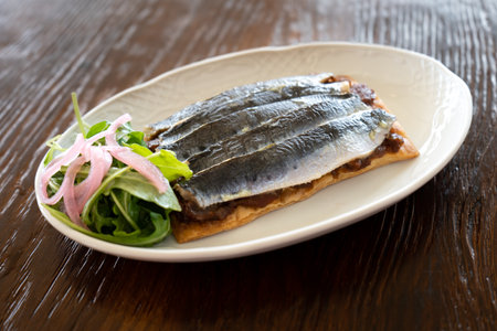 Studio photo of a plate of sardines on toast with salad, gourmet style. Spanish cuisine conceptの写真素材