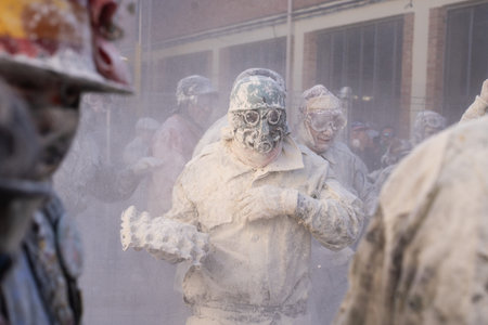 Ibi, Spain - December 28, 2022: Portrait of a man covered in flour carrying a tray of eggs to launch...