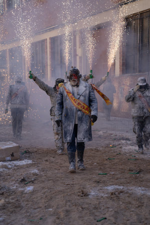 Ibi, Spain - December 28, 2022: Man dressed in a Spanish sash walks covered in flour with some...