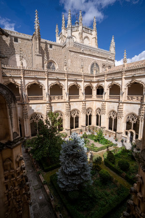 Toledo, Spain - March 17, 23: View of the Cloister of the Monastery of San Juan de los Reyes, built in the 15th century in Gothic style with the church tower in the background, in Toledo, Spainのeditorial素材
