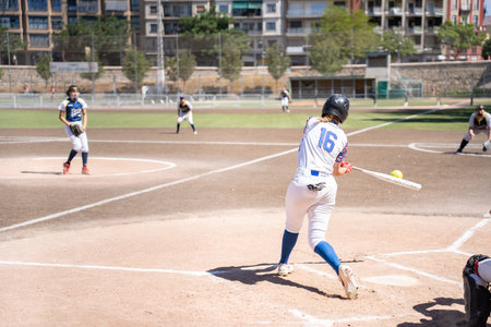 Valencia, Spain - May 14, 2023: A girl from her back turned in her team's uniform hitting the ball...