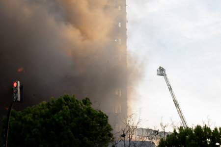 Valencia, Spain - February 22, 2024: Firefighters try to access the fire in a 14-storey residential building on Maestro Rodrigo street with General AvilÃ©s in the city of Valencia that burns completely quicklyのeditorial素材