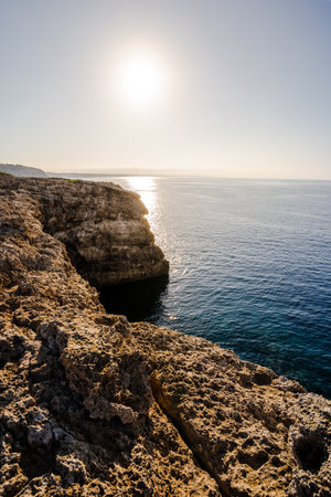 The sun rising on the south coast of rocky cliffs and calm water on the island of Menorca, Balearic Islands, Spain. Spanish tourism conceptの写真素材