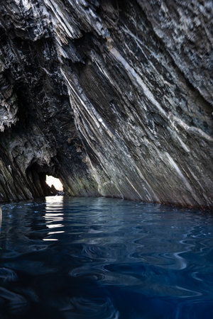 Rocky tunnel where you can see the different strata, in the water between the cliffs of the coast near Masua, south of the island of Sardinia with crystal clear waters. Active tourism conceptの写真素材