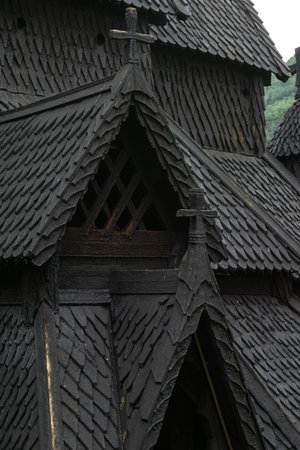 Close-up of the intricate wooden roof details of Borgund Stave Church, a 12th-century Norwegian Viking church, showing medieval craftsmanship and dark weathered textures. Medieval Viking templeの写真素材