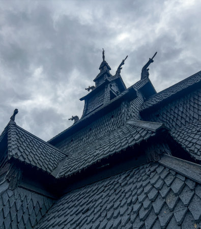 Low angle view of the wooden roof of the 12th century Norwegian Viking stave of Borgund church, with medieval craftsmanship bellow a cloudy sky. Medieval Viking templeの写真素材