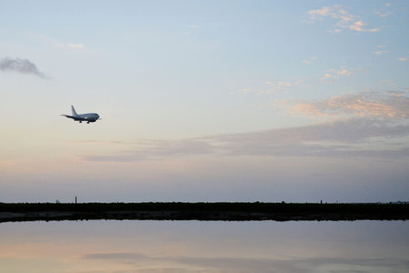 a passenger plane landing on an island at sunset