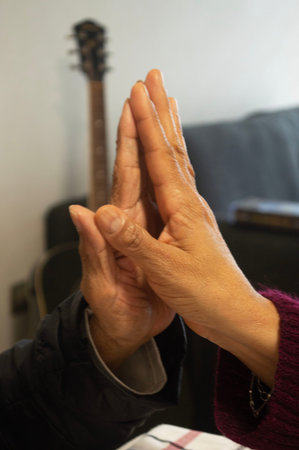 the hands of an elderly woman and a young woman