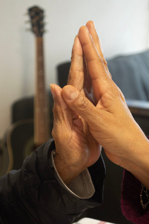 the hands of an elderly woman and a young woman
