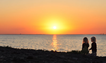 some children watching a sunset at the sea generated with AIの写真素材
