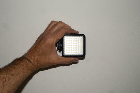 a hand holding a small led lightの写真素材