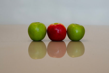 some green apples and a red appleの写真素材