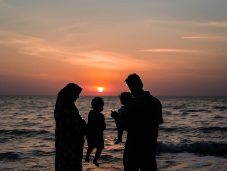 the silhouette of a family watching a sunset at the seaの写真素材