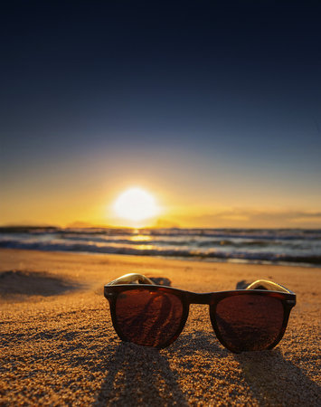 some sunglasses on rent on a beach at sunsetの写真素材