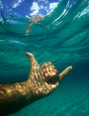 a hand under the sea making the symbol of all good in Hawaiianの写真素材