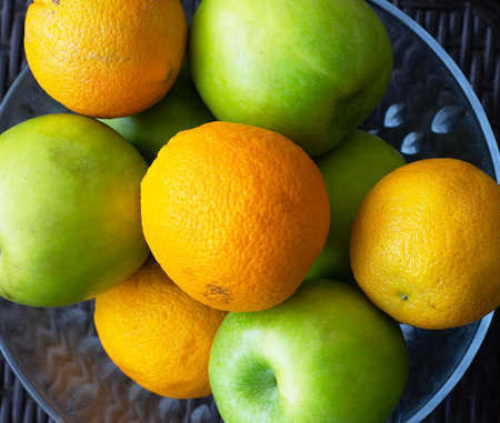 some apples and some oranges in a glass bowlの写真素材