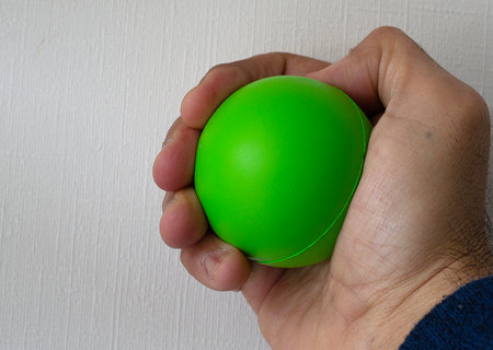 a man's hand squeezing a medicine or anti-stress ballの写真素材
