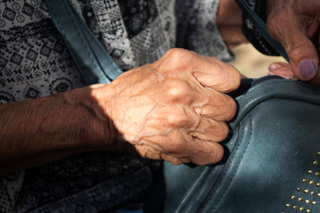 some hands of an old woman opening her purseの写真素材