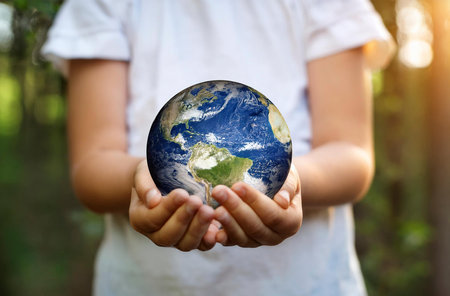 the planet earth in the hands of a child, celebrating earth dayの写真素材