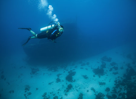 A scuba diver explores the famous MV Superior Producer shipwreck off the coast of CuraÃ§aoの写真素材