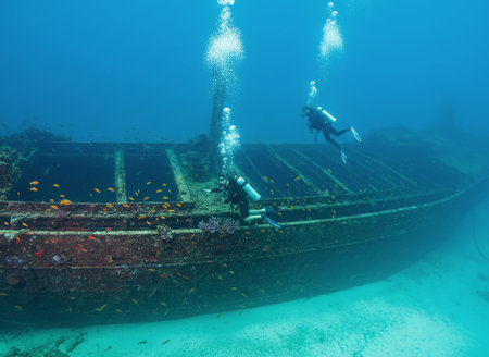 Image of a diver descending towards a sunken ship off the coast of CuraÃ§ao.