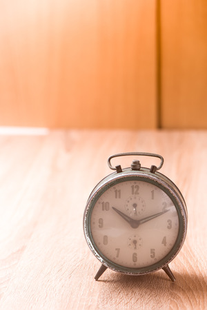 Old clock on wood tableの写真素材